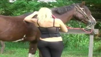 Cute blondie with big boobies is sucking her horse's big prick